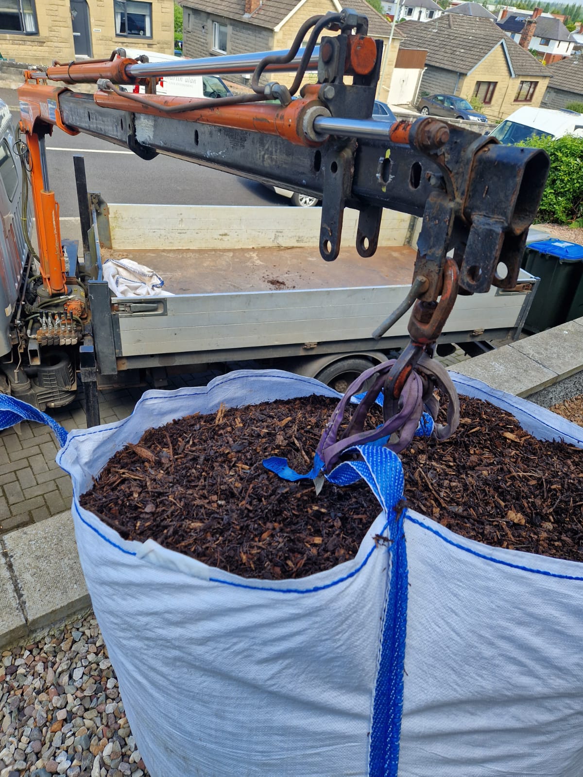 Freshly mulched flower bed with dark bark under mature trees