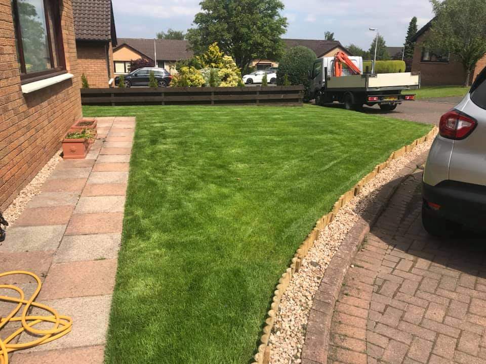 Completed artificial turf lawn installation with clean edging